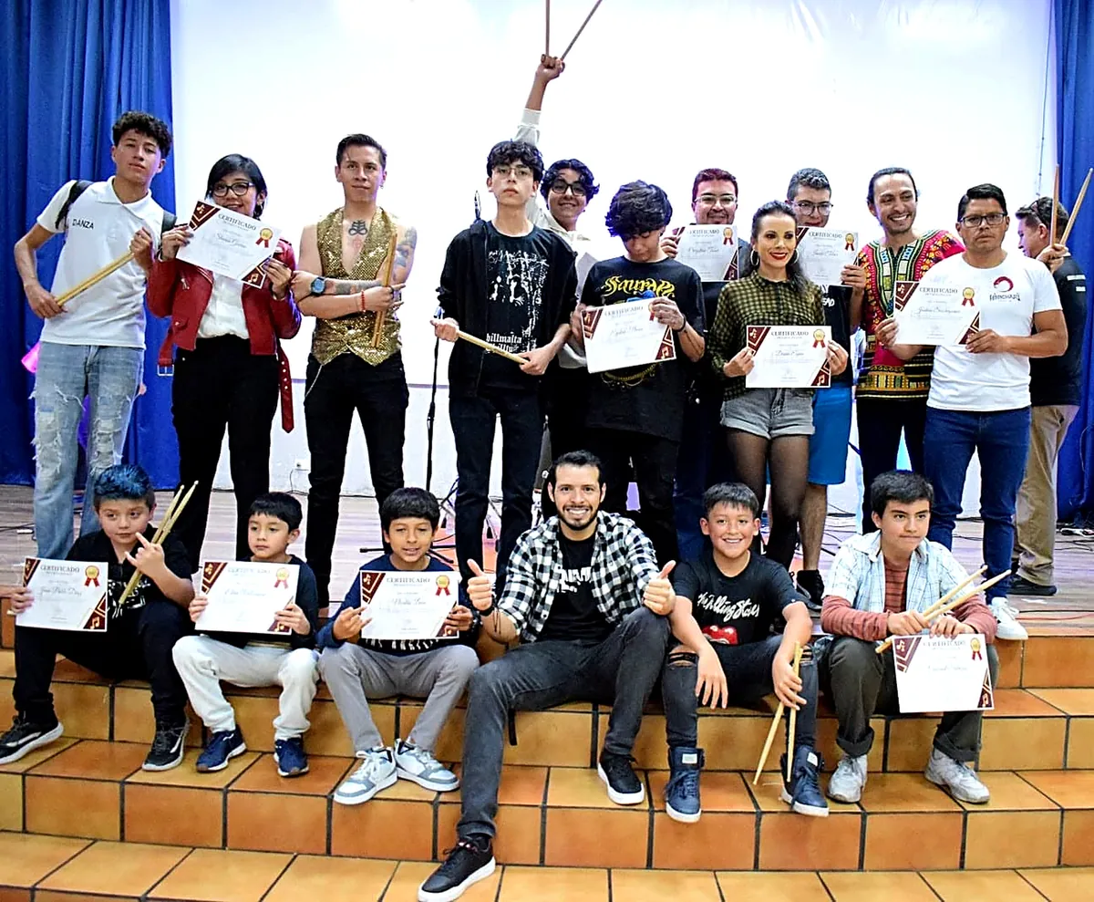 Jorge con estudiantes de batería y sus certificados tras un concierto en Quito